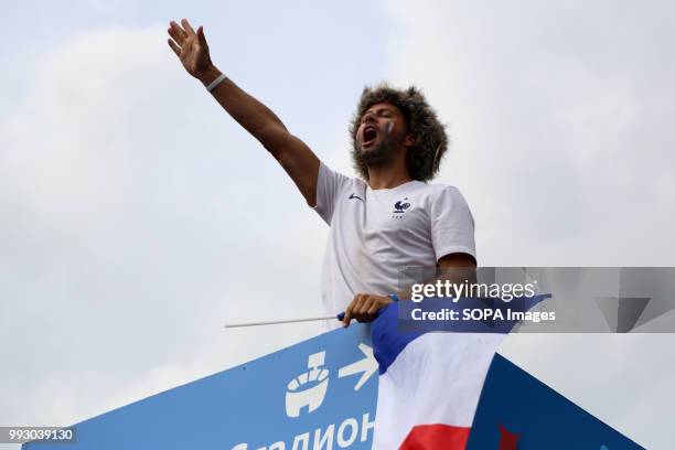 French football fan seen holding a french national flag. French football fans celebrate their national football team victory over uruguay during the...