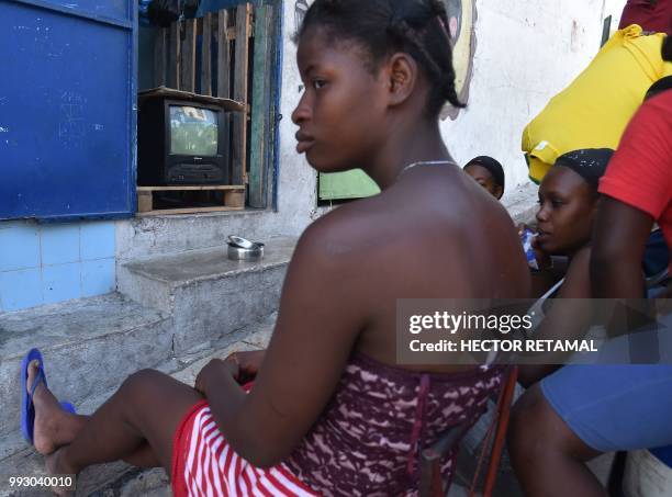 Haitians gather before a small television set watching a telecast of the Russia 2018 World Cup quarter-final football match between Brazil and...