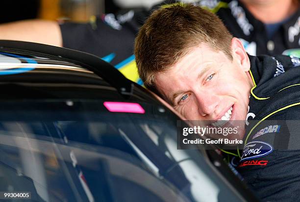 Carl Edwards, driver of the Aflac Ford, leans in his car in the garage during practice for the NASCAR Sprint Cup Series Autism Speaks 400 at Dover...