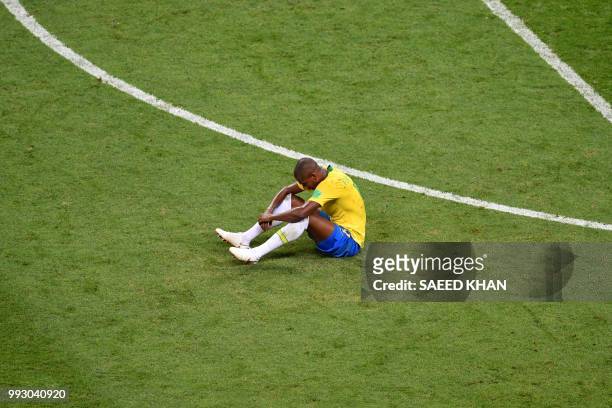 Brazil's midfielder Fernandinho sits on the field at the end of the Russia 2018 World Cup quarter-final football match between Brazil and Belgium at...