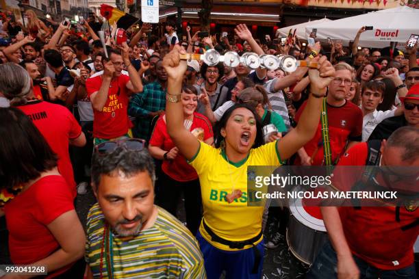 Belgian supporters celebrate and a Brazil supporter reacts during the Russia 2018 World Cup quarter-final football match between Brazil and Belgium,...