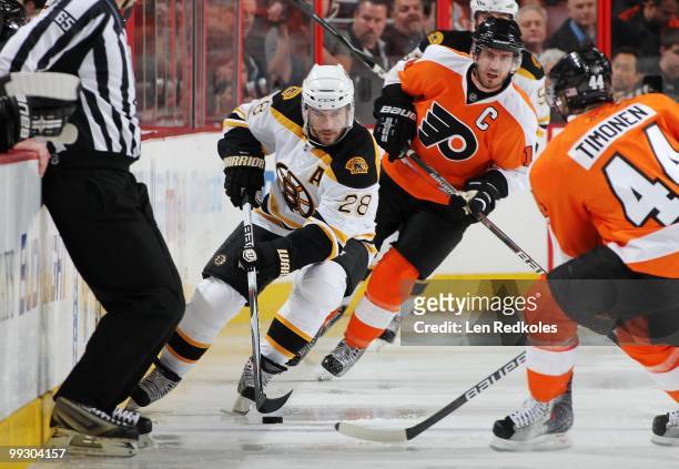Mark Recchi of the Boston Bruins skates with the puck against Mike Richards and Kimmo Timonen of the Philadelphia Flyers in Game Six of the Eastern...