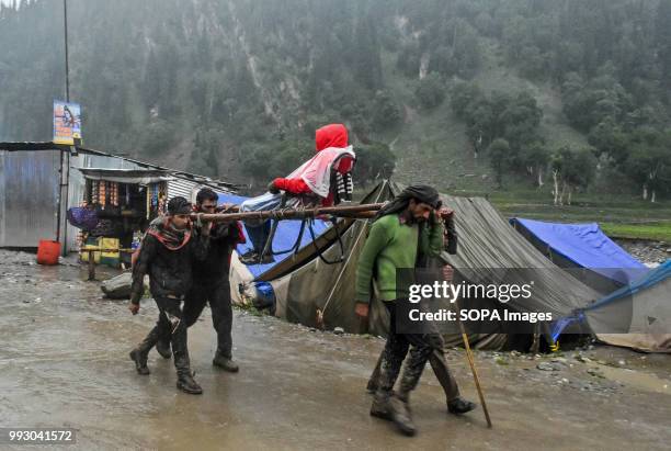 Hindu pilgrim is carried on a palanquin by Kashmiri bearers. Thousands of pilgrims annually go to the remote Himalayan shrine of Amarnath at 3,888...