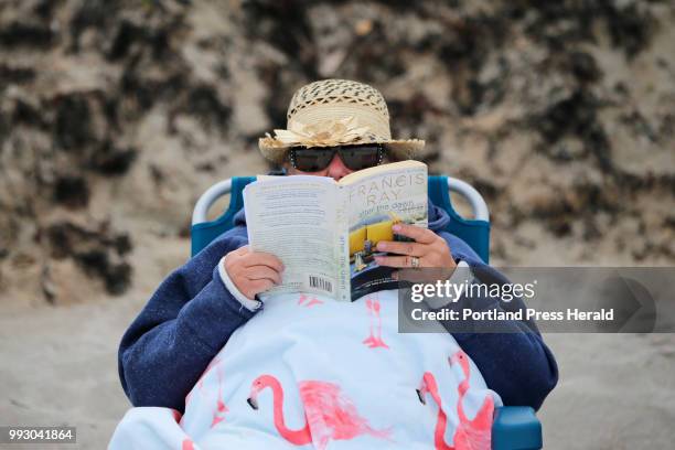 Margaret Wagner of Perth-Andover, NB, reads a novel that she jokingly described as "trash" while sitting on a beach chair Thursday at Crescent Beach...