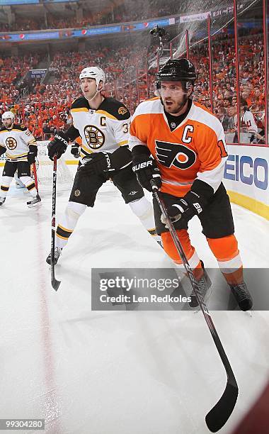 Mike Richards of the Philadelphia Flyers skates in the corner against Zdeno Chara of the Boston Bruins in Game Six of the Eastern Conference...