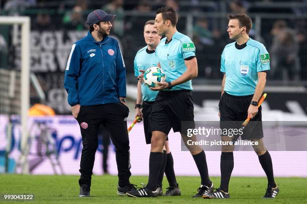 Coach Sandro Schwarz of Mainz discusses with referee Sven Jablonski during the half-time break of the German Bundesliga soccer match between Borussia...