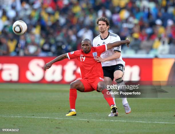 Jermain Defoe of England holds off Arne Friedrich of Germany during a FIFA World Cup Round of 16 match at the Free State Stadium on June 27, 2010 in...