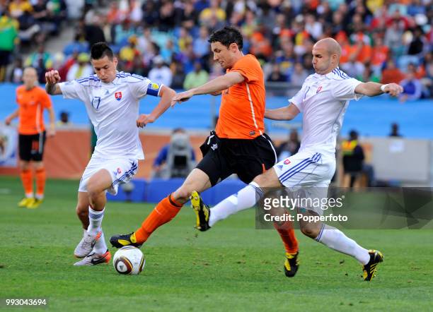 Mark van Bommel of the Netherlands is challenged by Marek Hamsik and Robert Vittek of Slovakia during a FIFA World Cup Round of 16 match at the Moses...