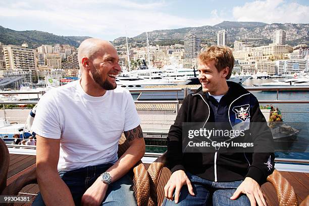 Skier Marco Buechel and Sebastian Vettel of Germany and Red Bull Racing are seen on the Red Bull Energy Station during previews to the Monaco Formula...