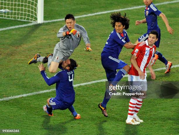 Marcus Tulio Tanaka of Japan is taken out by his goalkeeper Eiji Kawashima during the FIFA World Cup Round of 16 match between Paraguay and Japan at...