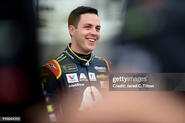 Alex Bowman, driver of the Axalta Chevrolet, stands by his car during qualifying for the Monster Energy NASCAR Cup Series Coke Zero Sugar 400 at...