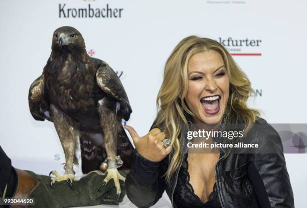 Singer Anastacia poses with hawk 'Attila', the mascot of soccer club Eintracht Frankfurt, during the arrival at the 36th German Sports Press Ball at...