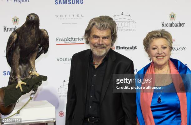 Mountaineer Reinhold Messner and actress Marie-Luise Marjan pose with hawk 'Attila', the mascot of soccer club Eintracht Frankfurt, during the...