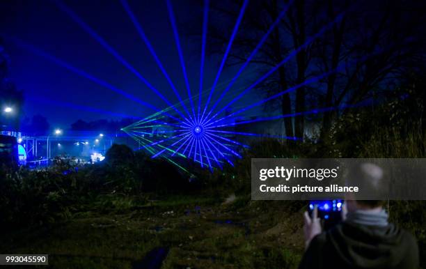 Visitors photograph a laser show at the German Electron Synchrotron campus in Hamburg, Germany, 04 November 2017. The Desy Day takes place as part of...