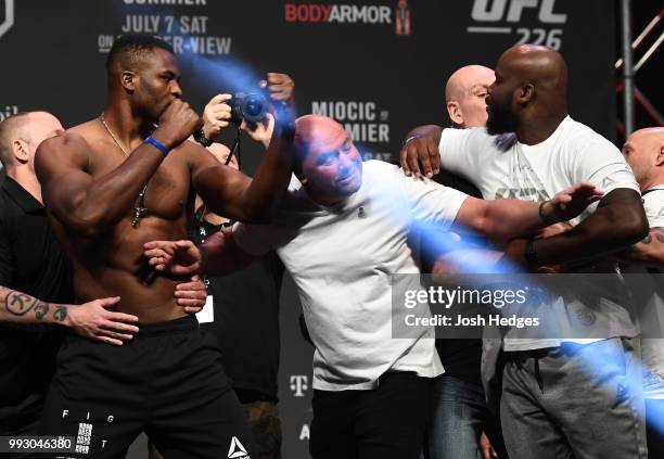 Opponents Francis Ngannou of Cameroon and Derrick Lewis face off during the UFC 226 weigh-in inside T-Mobile Arena on July 6, 2018 in Las Vegas,...