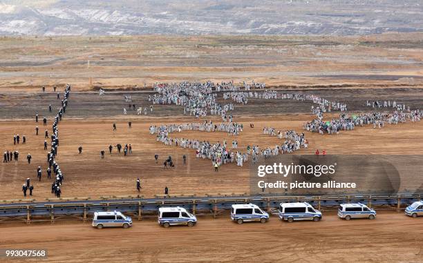 Police officers surround activists of the 'Ende Gelaende' group during an action to blockade coal operations at the strip mine of Hambach in Kerpen,...