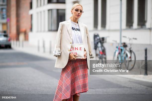 Viktoria Rader wearing red plaid skirt, asymmetrical sneaker, Celine clutch and blazer seen outside William Fan during the Berlin Fashion Week July...