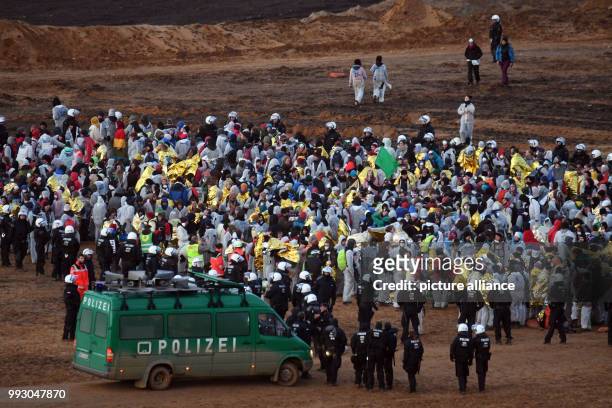 Police officers surround activists of the 'Ende Gelaende' group during an action to blockade coal operations at the strip mine of Hambach in Kerpen,...