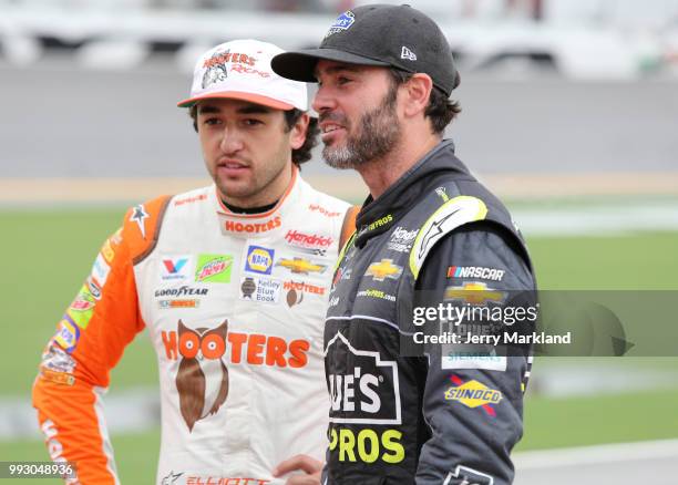 Chase Elliott, driver of the Hooters Chevrolet, talks with Jimmie Johnson, driver of the Lowe's for Pros Chevrolet, during qualifying for the Monster...