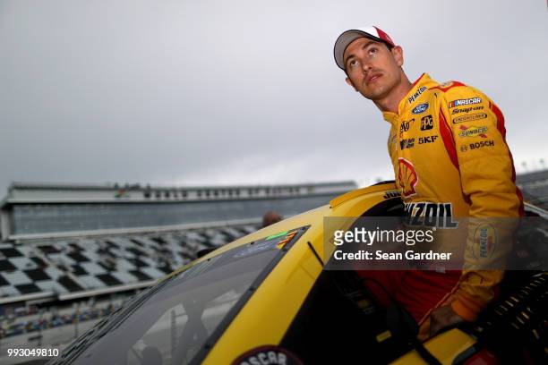Joey Logano, driver of the Shell Pennzoil Ford, gets into his car during qualifying for the Monster Energy NASCAR Cup Series Coke Zero Sugar 400 at...