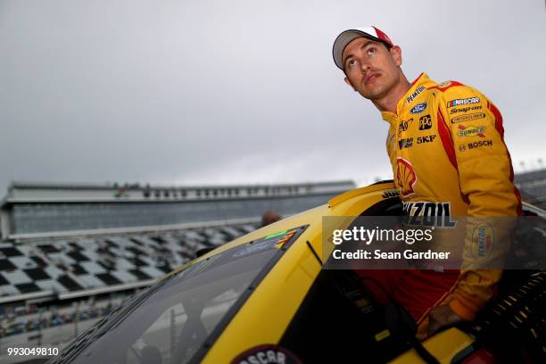 Joey Logano, driver of the Shell Pennzoil Ford, gets into his car during qualifying for the Monster Energy NASCAR Cup Series Coke Zero Sugar 400 at...