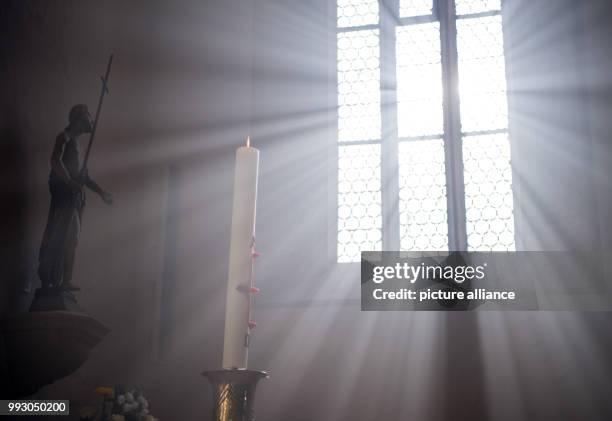 Rays of sun fall through a church window in Rottenburg am Neckar, Germany, 4 November 2017. Photo: Sebastian Gollnow/dpa