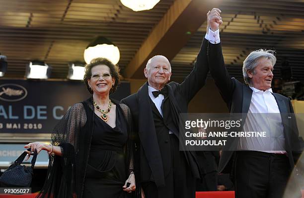 French actor Alain Delon holds hands with the president of the festival Gilles Jacob as he arrives with Italian actress Claudia Cardinale for the...