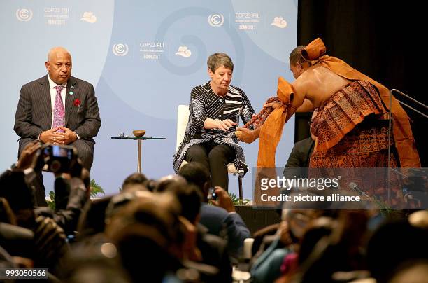 Fiji's Prime Minister and President of COP23/CMP13, Frank Bainimarama watches as German Minister for Environment, Barbara Hendricks receives a...