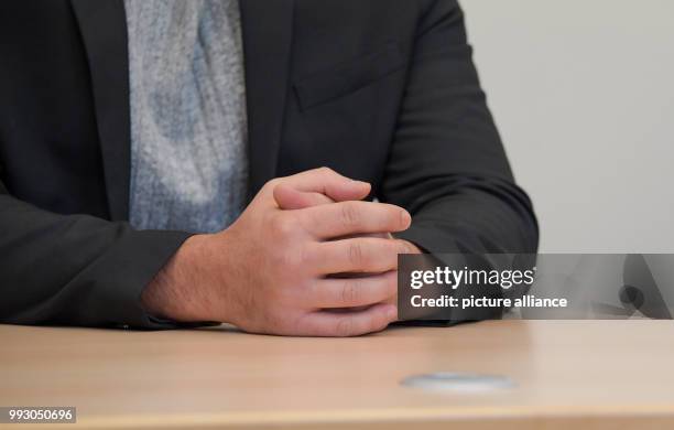 The accused of aggravated robbery joins his hands on the table during the trial in the criminal justice building in Hamburg, Germany, 6 November...