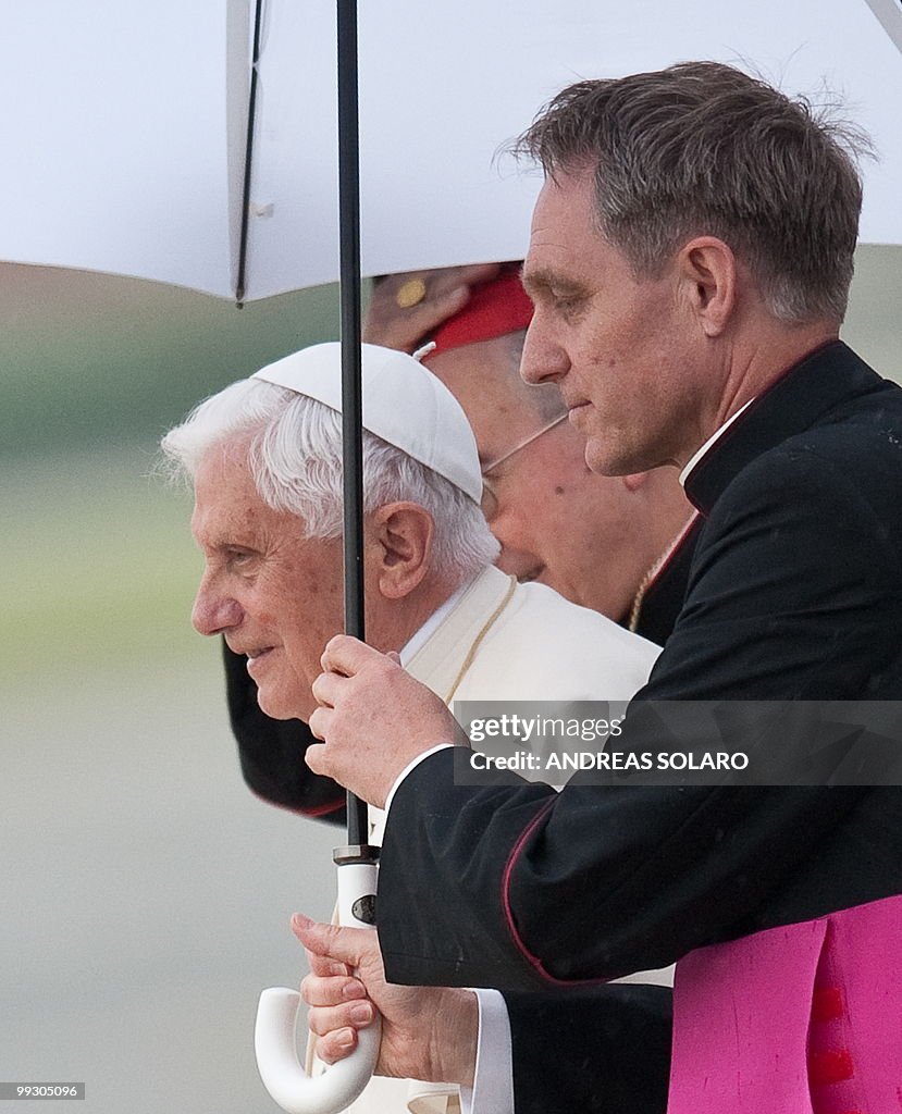 Pope Benedict XVI (C) walks under an umb