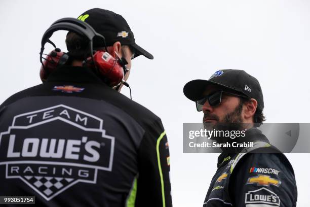 Jimmie Johnson, driver of the Lowe's for Pros Chevrolet, speaks with his crew chief Chad Knaus on the grid during qualifying for the Monster Energy...