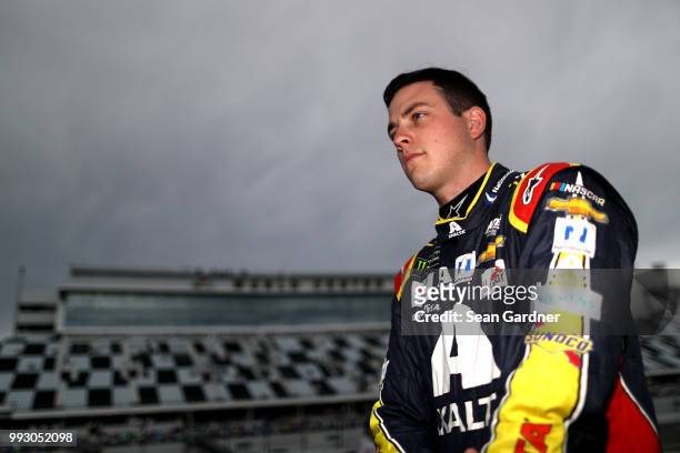 Alex Bowman, driver of the Axalta Chevrolet, stands by his car during qualifying for the Monster Energy NASCAR Cup Series Coke Zero Sugar 400 at...