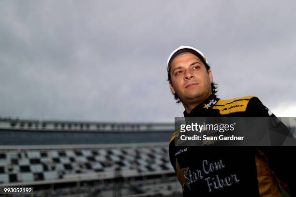 Landon Cassill, driver of the Star Com Fiber Chevrolet, walks to his car during qualifying for the Monster Energy NASCAR Cup Series Coke Zero Sugar...