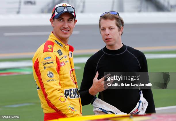 Joey Logano, driver of the Shell Pennzoil Ford, and Brad Keselowski, driver of the Stars Stripes and Lites Ford, talk during qualifying for the...