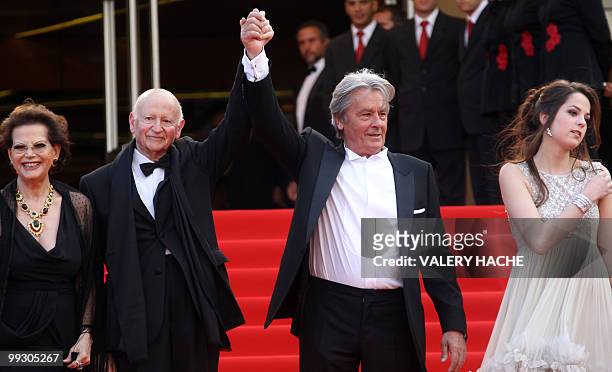 French actor Alain Delon holds hands with the president of the festival Gilles Jacob as he arrives with Italian actress Claudia Cardinale and his...