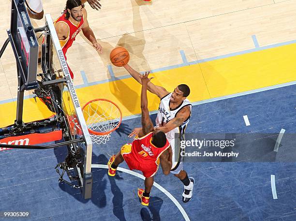 Mike Conley of the Memphis Grizzlies puts a shot up against Aaron Brooks of the Houston Rockets during the game at the FedExForum on April 6, 2010 in...