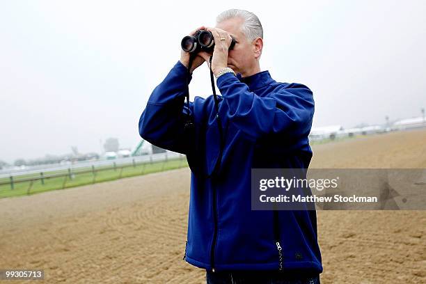 Trainer Todd Pletcher watches Super Saver, riden by Kevin Willey, during morning excersise in preparation for the 135th Preakness Stakes at Pimlico...