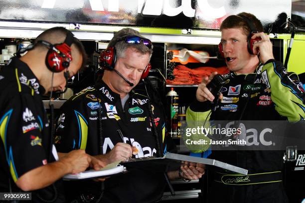 Carl Edwards , driver of the AFLAC Ford, speaks with crew chief Bob Osborne and a crew member , in the garage during practice for the NASCAR Sprint...