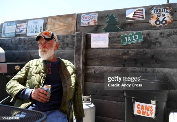 Spring Fire evacuee John Ray, enjoys a cold beer under an umbrella at The Lodge Motel July 06, 2018. Ray was evacuated from the Forbes Park area, an...