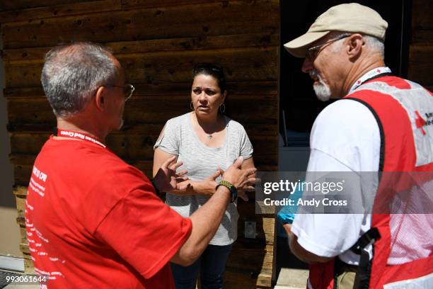 American Red Cross volunteers Roger Enix, left, and Arden Anderson, right, talk with Caroline Shafer, center, the manager of The Lodge Motel in Fort...