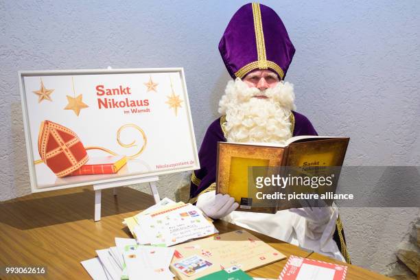 Performer in Nikolaus costume sitting in St. Nikolaus, Germany, 06 November 2017. Lying on the table are letters that arrived to the Nikolaus Post...