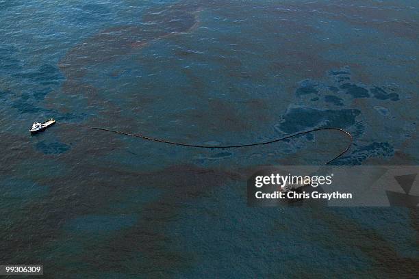 Boat works to collect oil that has leaked from the Deepwater Horizon wellhead in the Gulf of Mexico on April 28, 2010 near New Orleans, Louisiana. An...