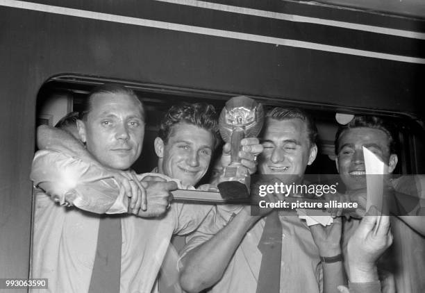 The players (l-r9 Max Morlock, Hans Schaefer, Jupp Posipal and Hans Bauer of the German national soccer team present the Jules Rimet trophy at the...