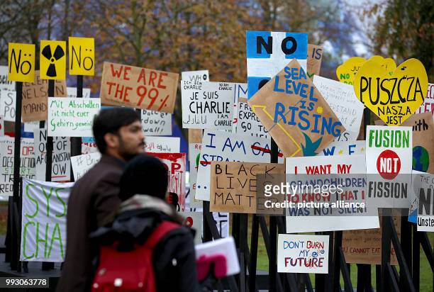 Participants in the World Climate Conference standing holding signs with historical slogans on climate change in Bonn, Germany, 07 November 2017. The...