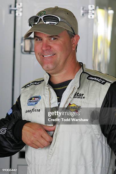 Jason Keller, driver of the TriStarMotorsports Chevrolet, stands in the garage during practice for the NASCAR Nationwide Series Heluva Good 200 at...