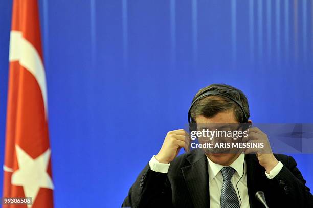 Turkish Foreign Minister Ahmet Davutoglu adjusts his earphones during a meeting between Turkey's Prime Minister Recep Tayyip Erdogan and Greek Prime...