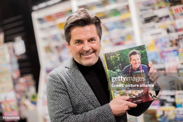 Former Modern Talking singer Thomas Anders holds up his cookbook 'Modern Cooking - Einfach, Lecker, Anders' at the Mayerschen Buchhandlung book store...