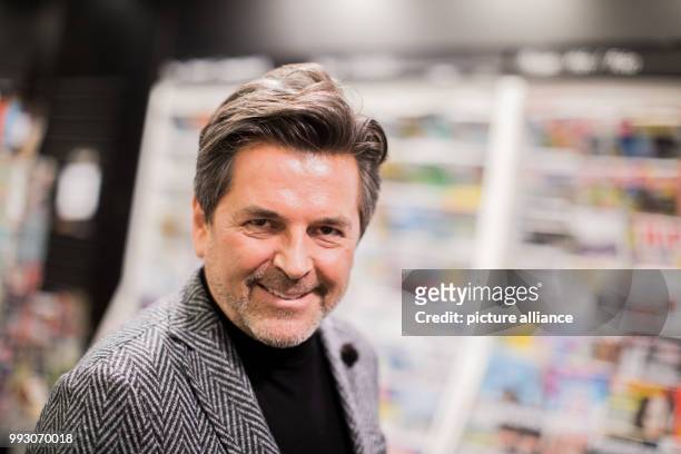 Former Modern Talking singer Thomas Anders holds up his cookbook 'Modern Cooking - Einfach, Lecker, Anders' at the Mayerschen Buchhandlung book store...