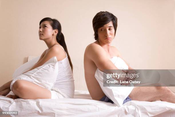 asian couple sitting on bed - amor não correspondido imagens e fotografias de stock