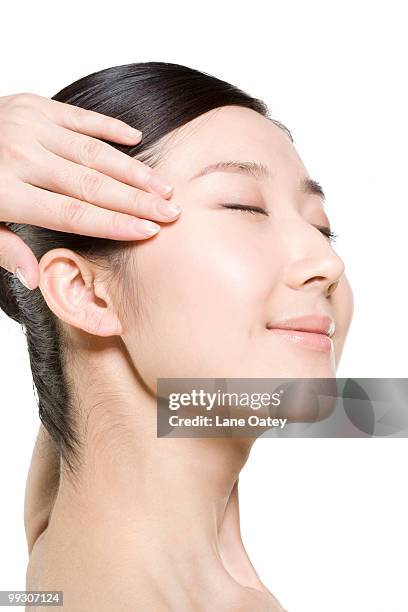 beauty shot of a young woman touching her face - natural portrait studio shot white background stock-fotos und bilder